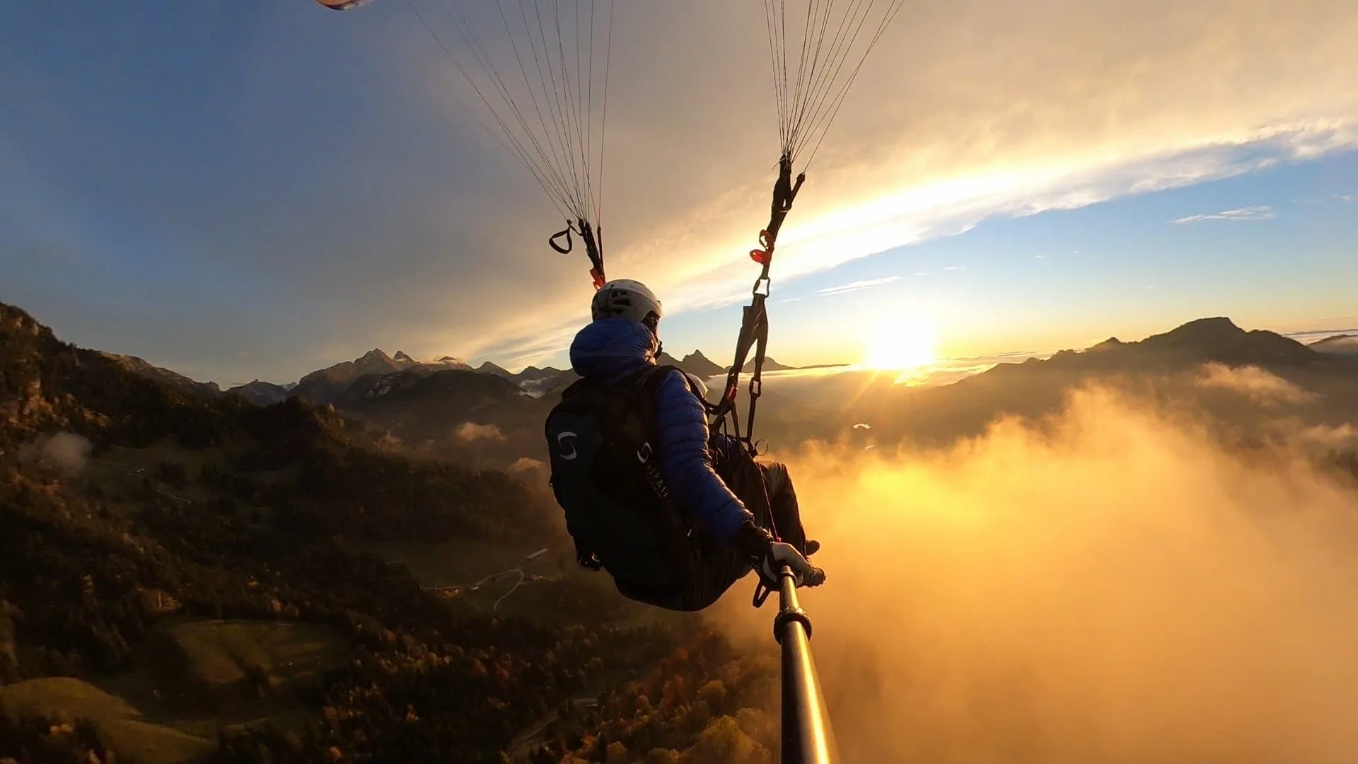 Vol en parapente biplace au coucher du soleil dans les montagnes du Valais.